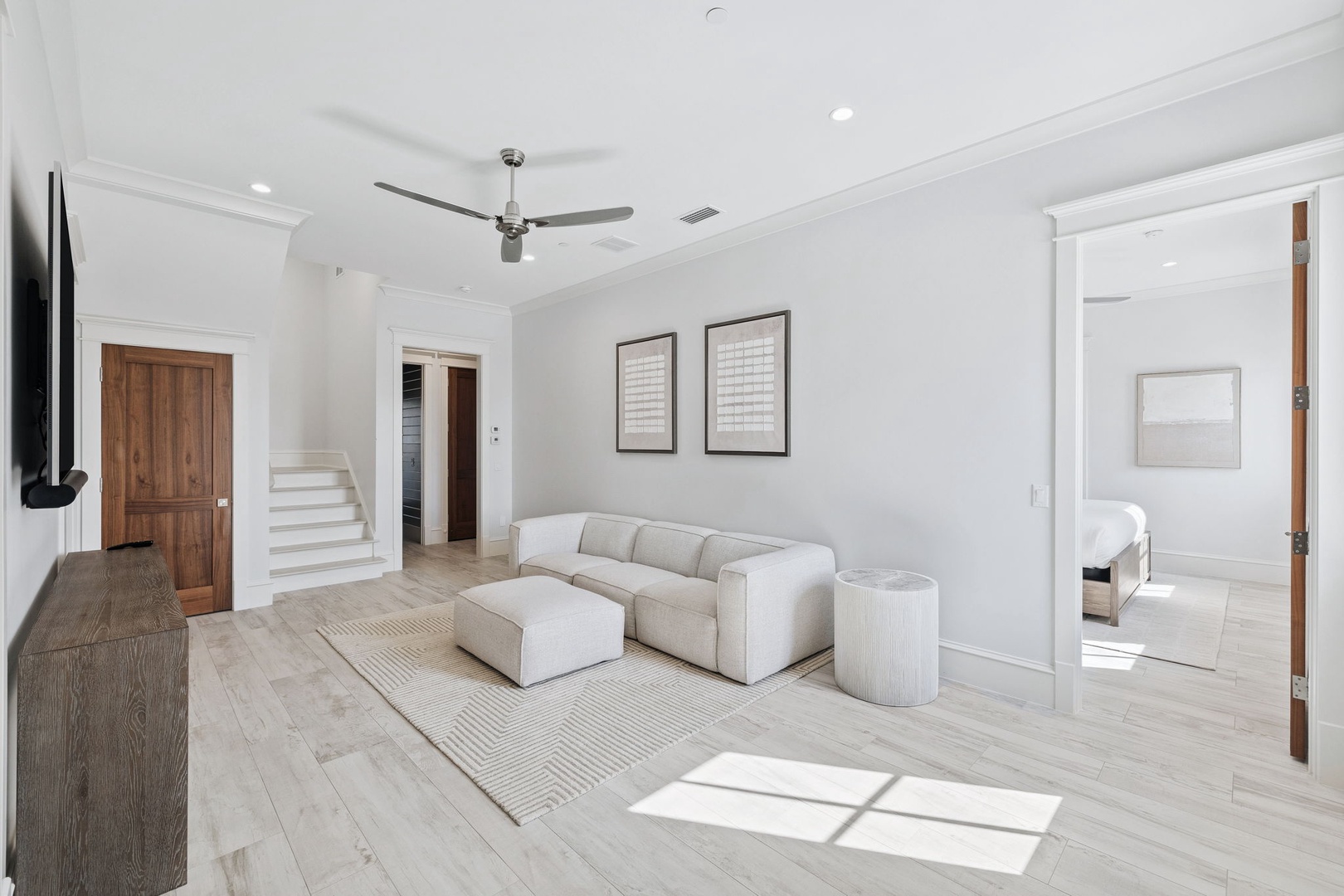 Unwind in your bright, contemporary living space featuring plush seating, warm wood floors, and natural light streaming in.