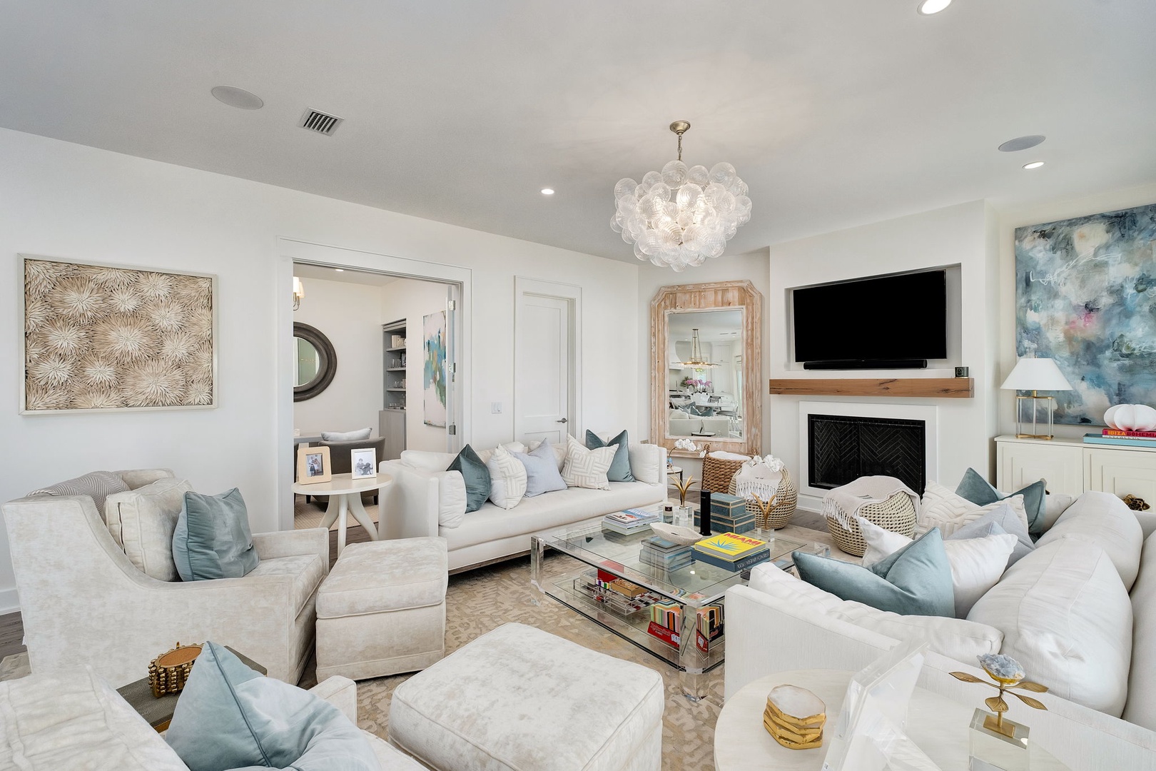 Step into your stylish coastal retreat—plush seating, elegant chandelier, and curated decor create the perfect space for you to unwind and gather with loved ones.