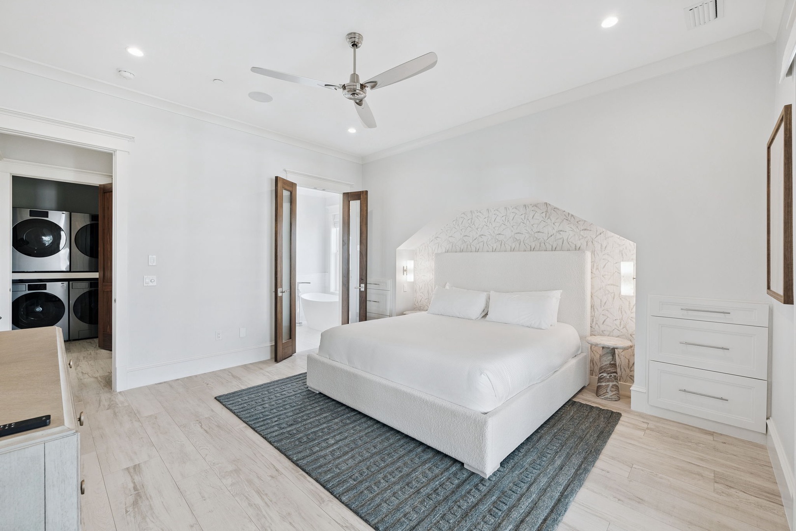 Drift into peaceful sleep in your elegant master bedroom, featuring crisp white linens and a stunning decorative headboard that creates the perfect retreat.