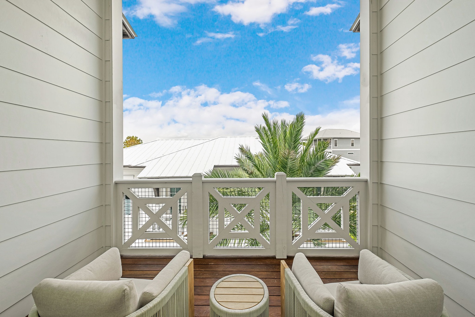 Settle into your private balcony with cozy seating and a charming view of palm trees and sunny skies—a perfect spot to unwind with morning coffee or evening conversation.