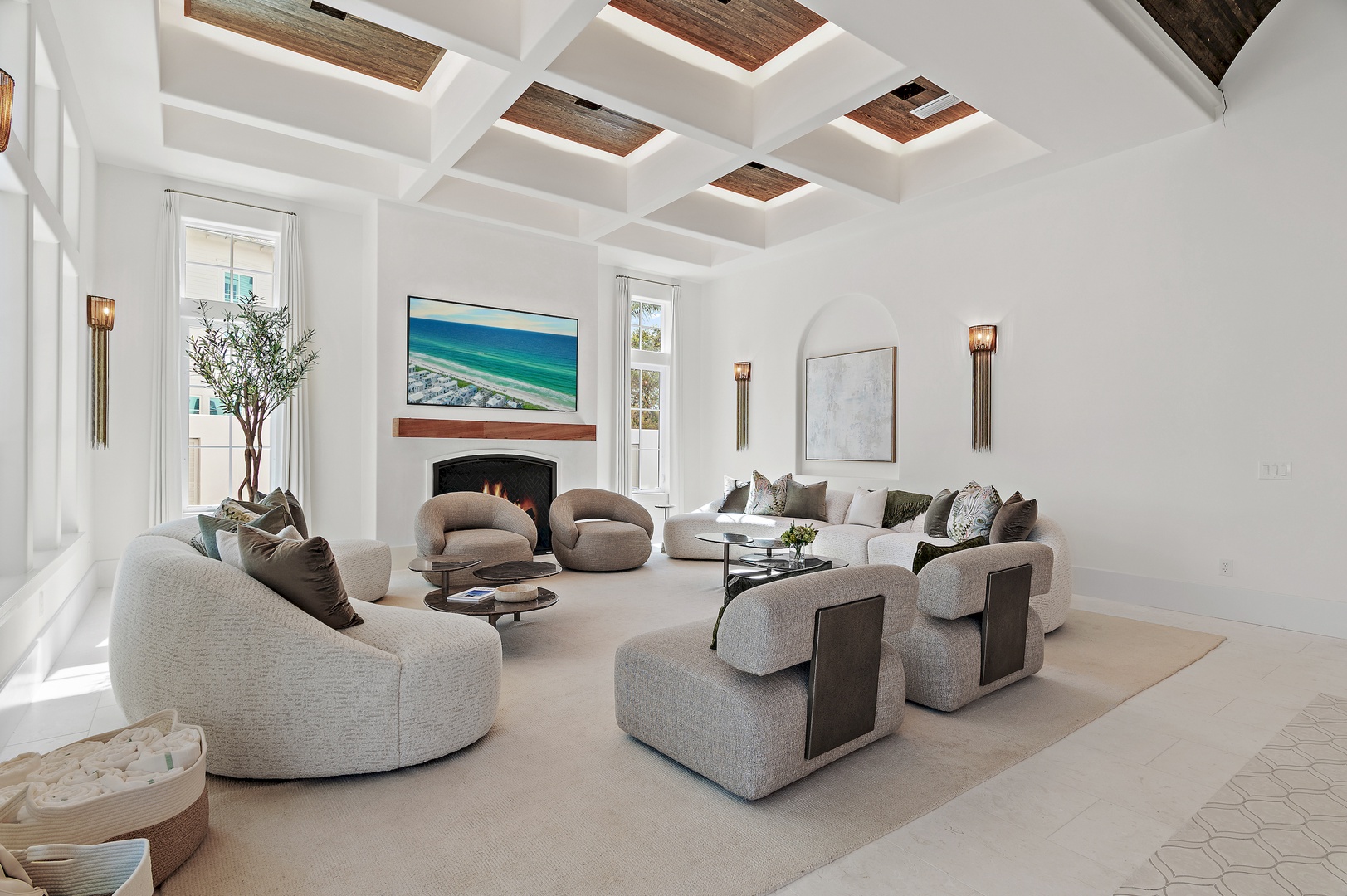 Sink into plush seating beneath stunning wood-beamed ceilings, where your coastal retreat invites relaxation by the fireplace with ocean-inspired art gracing bright, airy walls.