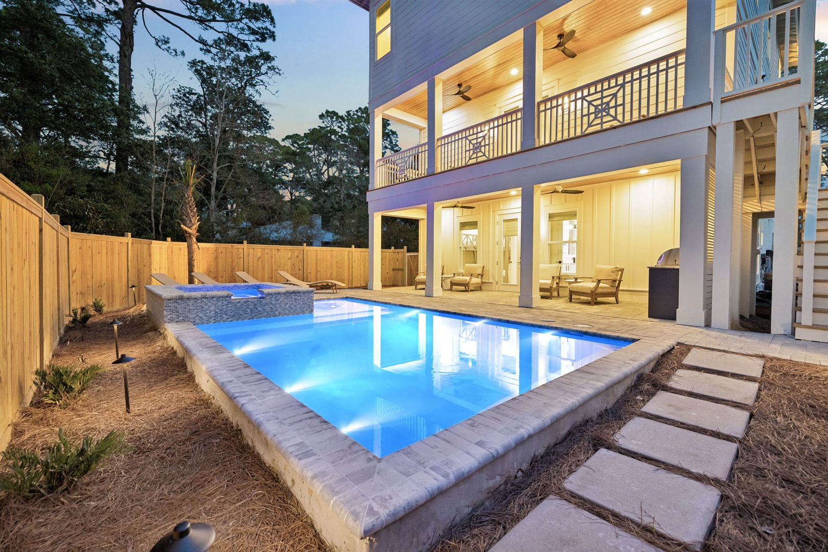 Stunning private pool glows at twilight, perfect for evening swims and relaxing after your coastal adventures.