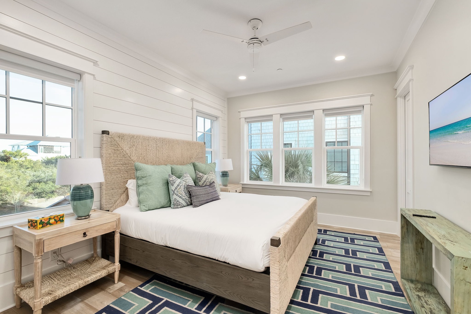Rest peacefully in your coastal-inspired bedroom with plush linens, ocean-hued accents, and bright windows framing beautiful views.
