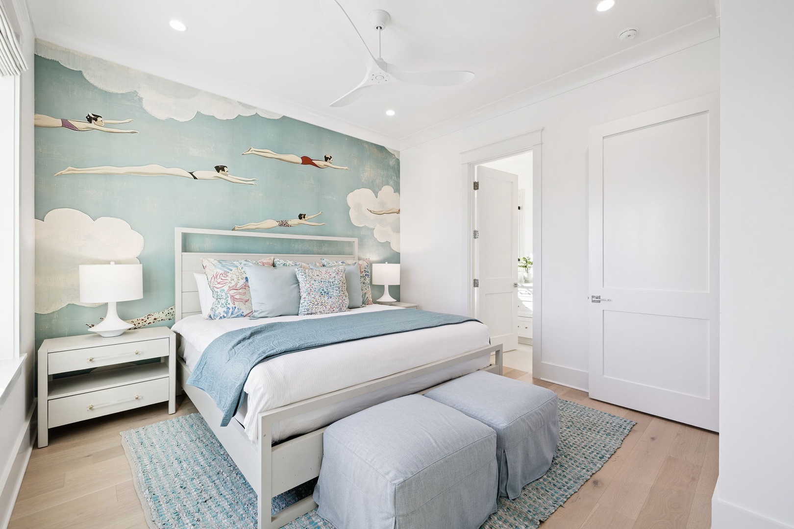 Drift into dreams in your whimsical bedroom where flying storks soar across sky-blue walls above crisp linens.
