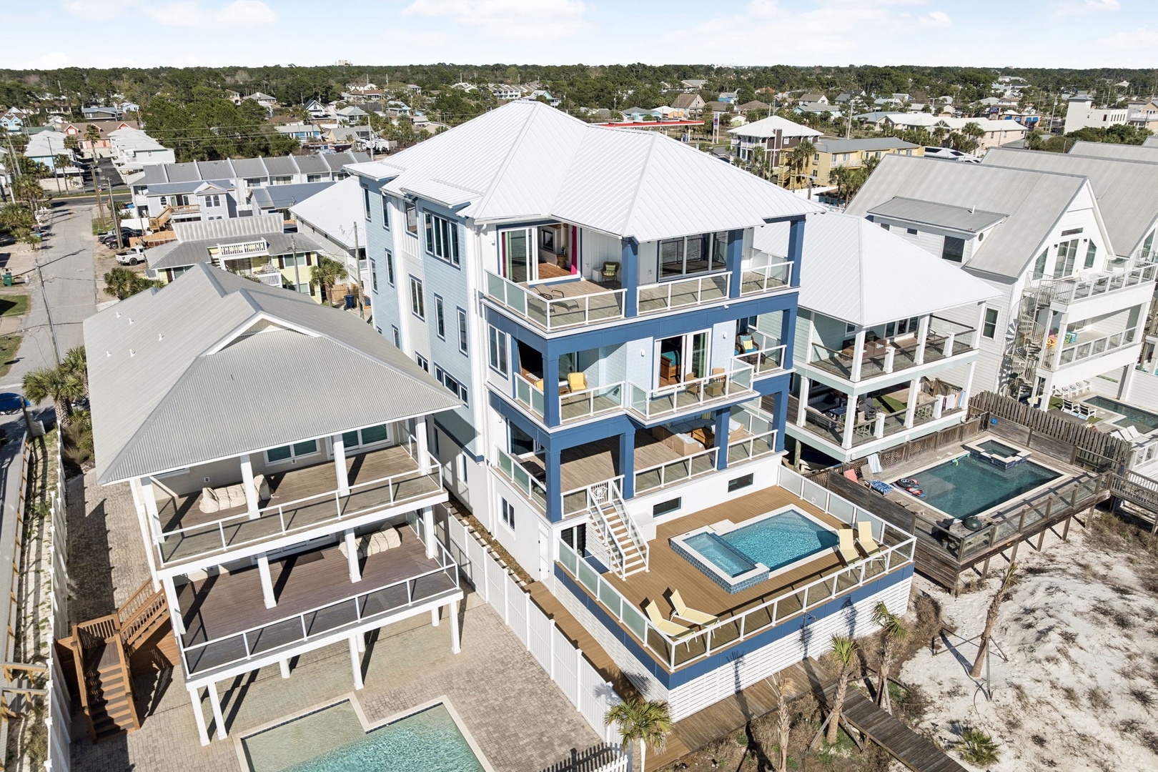 Stunning three-story beach house with private pool and multiple balconies in a coastal community.
