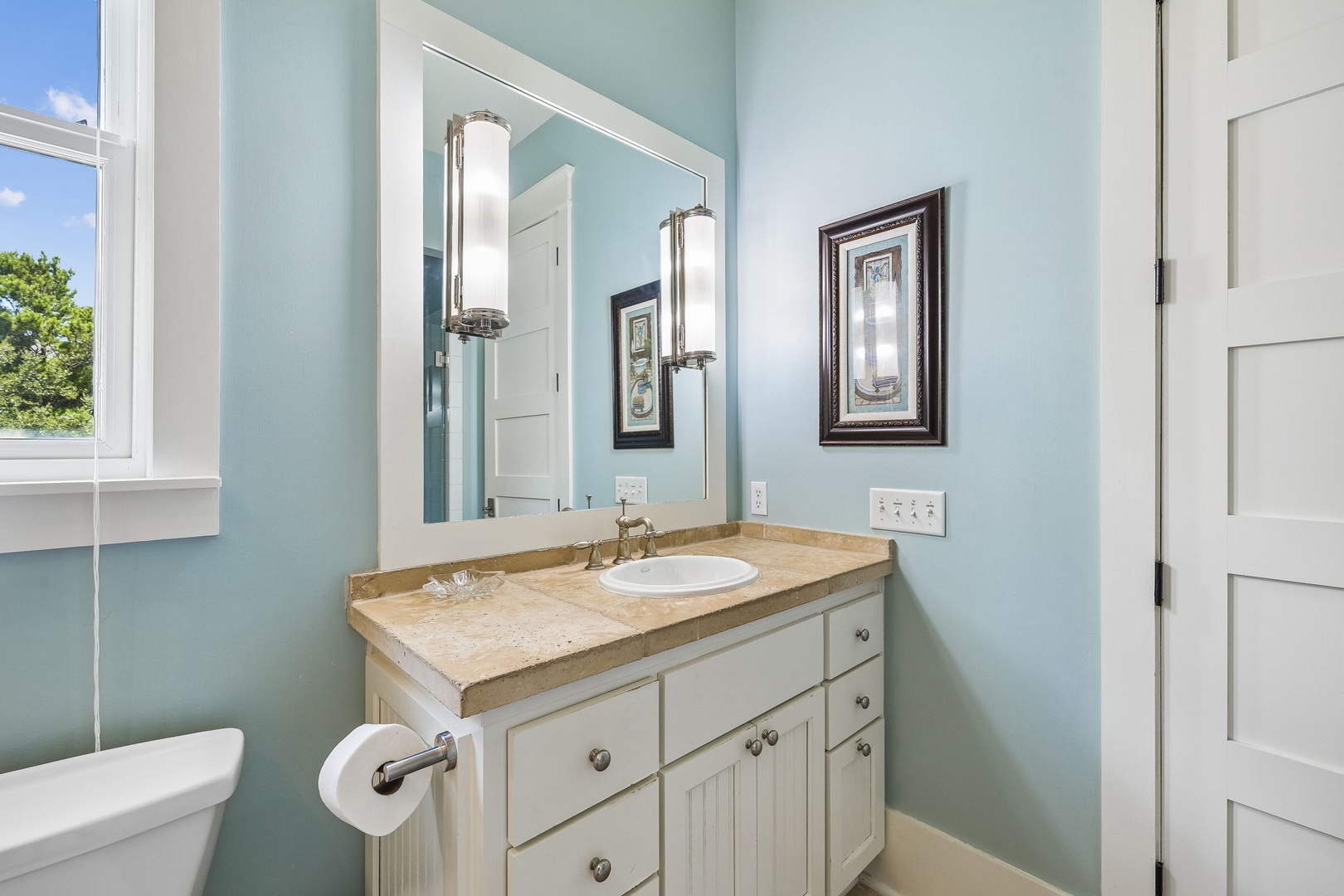 Step into this soothing bathroom, where calming blue tones and warm natural light create your perfect retreat.