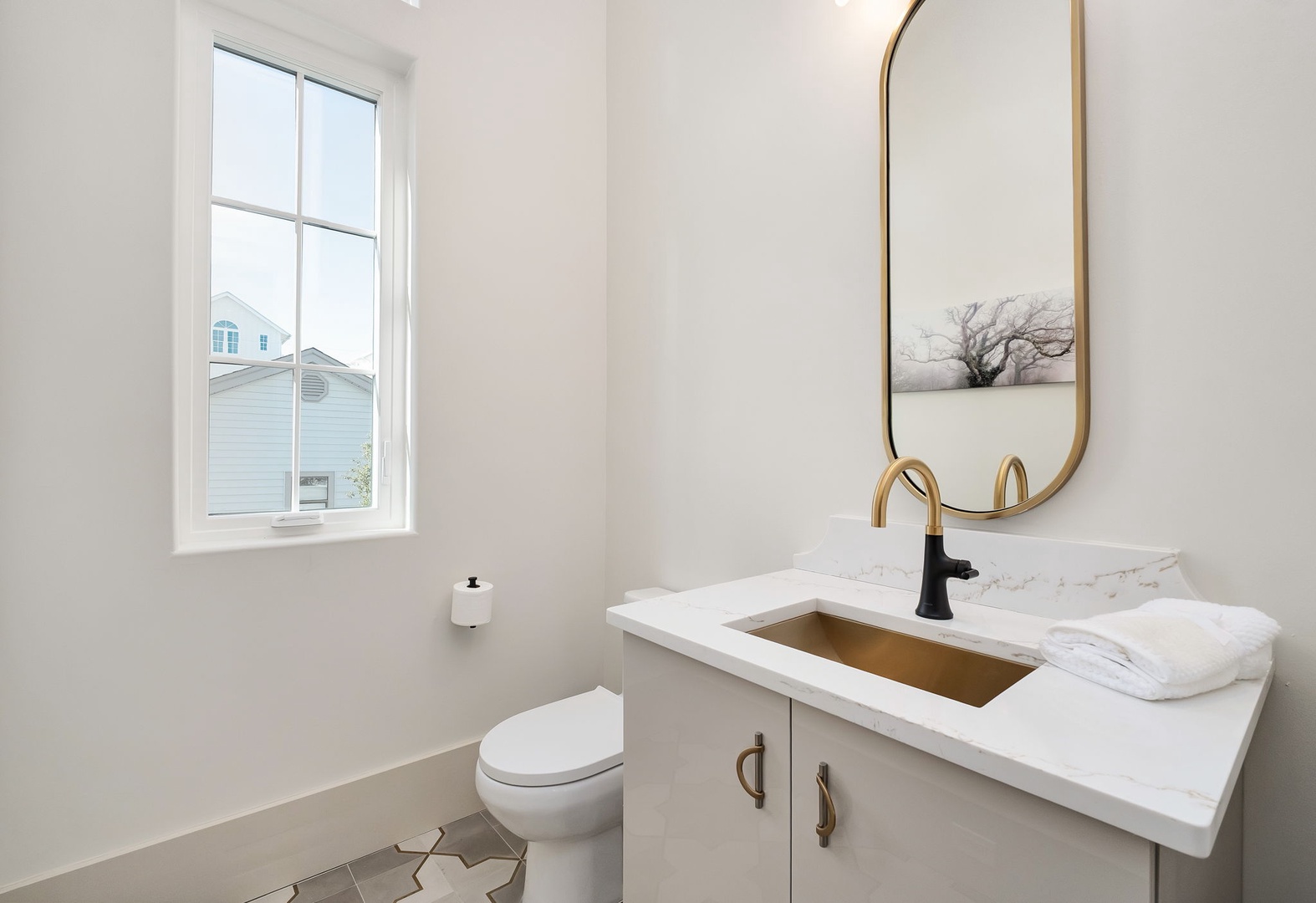 Your modern powder room features elegant marble countertops and brass fixtures, creating a sophisticated space for refreshing during your stay.