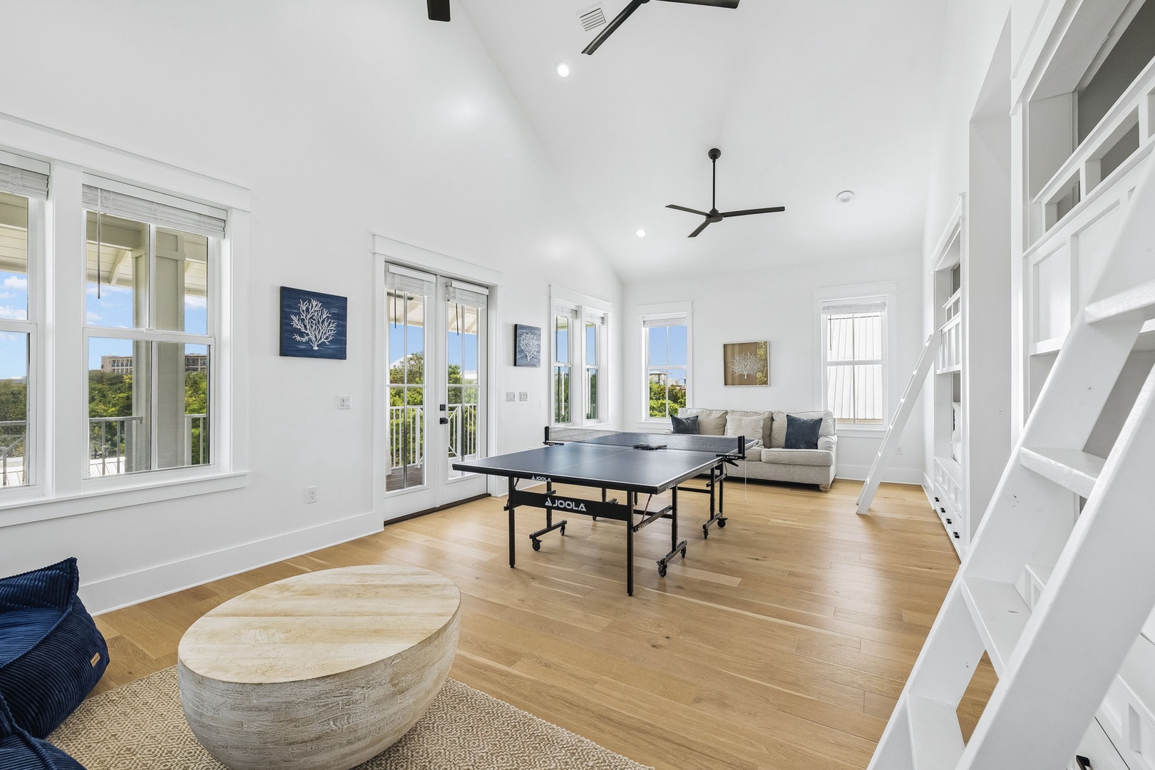 Your bright, open living space invites relaxation and play with soaring ceilings, warm hardwood floors, and plenty of natural light streaming through multiple windows and French doors.
