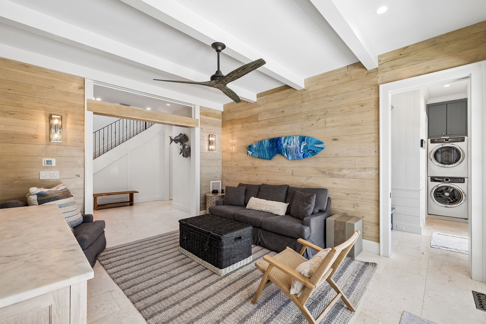 Settle into your open-plan coastal retreat with high ceilings, warm wood walls, and convenient in-unit laundry. The surfboard art and relaxed seating invite you to unwind in beachy style.