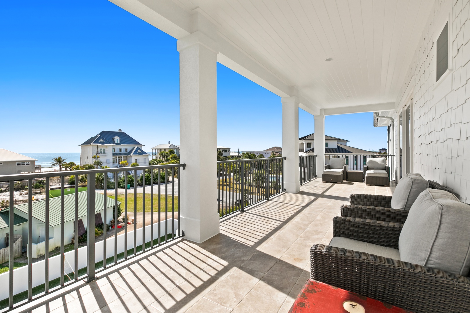 A covered coastal retreat features ocean glimpses and upscale homes from an elevated terrace—ideal for your morning coffee or sunset gathering.