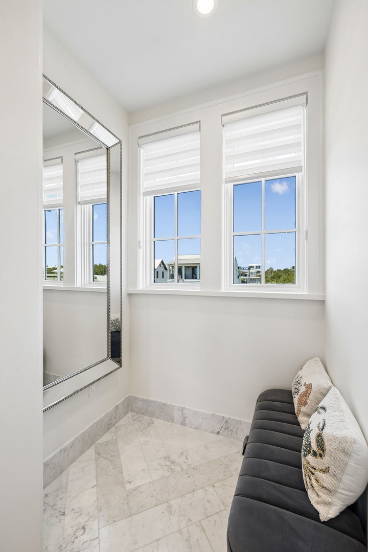 Relax in your cozy alcove with fresh natural light streaming through elegant windows. The plush seating and marble flooring create a peaceful retreat where you can unwind in comfort.