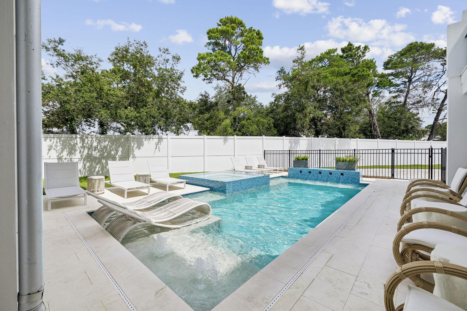 Step outside to your private heated pool surrounded by modern loungers, where sunlit water and lush tree views create the perfect backdrop for lazy afternoons and refreshing dips.