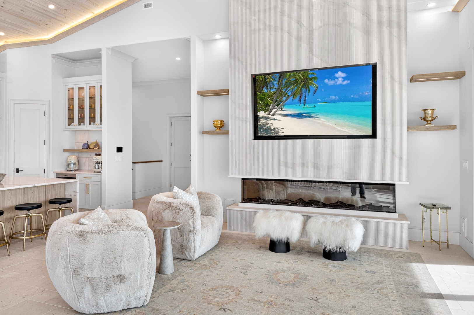 Your luxurious living space features plush seating around a modern fireplace, with entertainment ready on the wall-mounted TV.