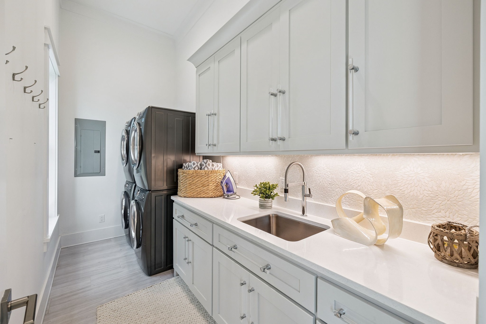 Your bright, organized laundry room makes chores effortless with crisp white cabinets and convenient countertop workspace.
