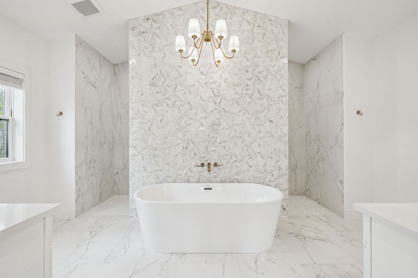 Indulge in pure luxury with your own marble sanctuary, featuring a soaking tub beneath an elegant chandelier for the ultimate relaxation experience.