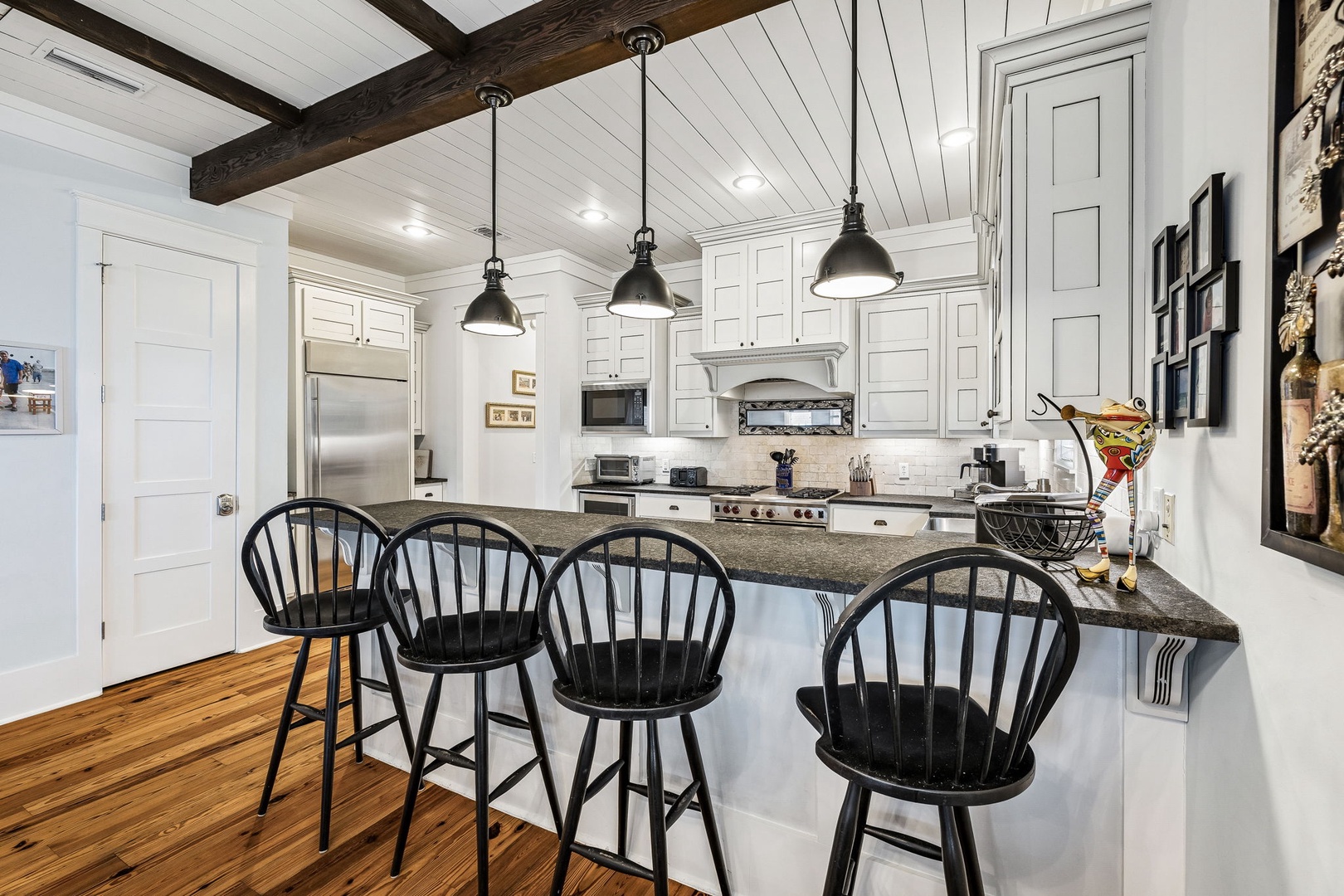 Your fully-equipped farmhouse kitchen invites you to gather around the island, where rustic wood beams and warm pendant lights create a welcoming space for cooking and conversation.
