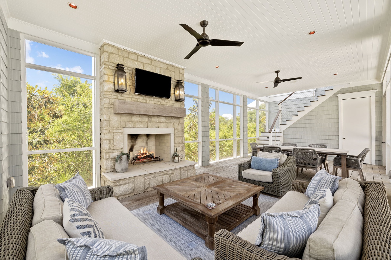 Relax in your sunlit screened porch, where a cozy stone fireplace and breezy ceiling fans create the perfect retreat. Sink into plush seating and enjoy peaceful treetop views—ideal for morning coffee or evening unwinding.
