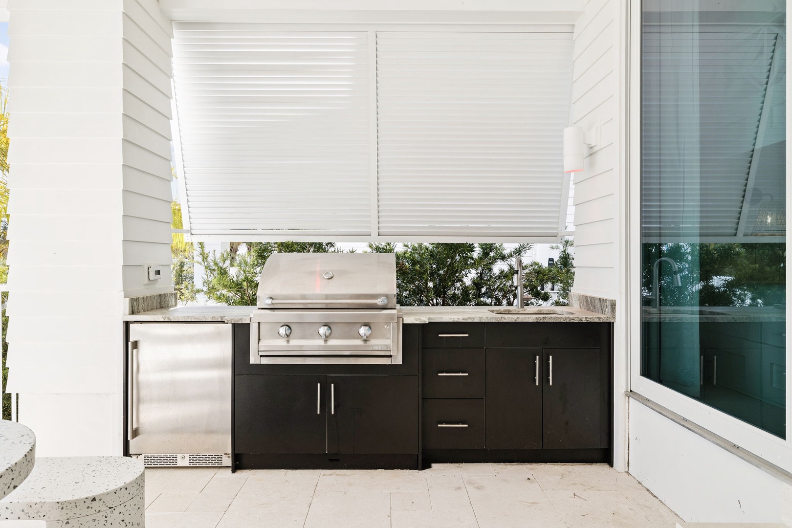 Your private outdoor kitchen awaits with sleek stainless steel appliances and ample counter space for al fresco dining preparation.