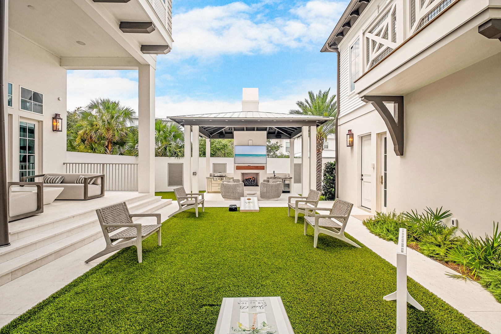 Step into your private courtyard where lush green grass meets coastal elegance. Unwind in plush seating under the pergola, and let the tropical palms and gentle breeze make every moment feel like paradise.