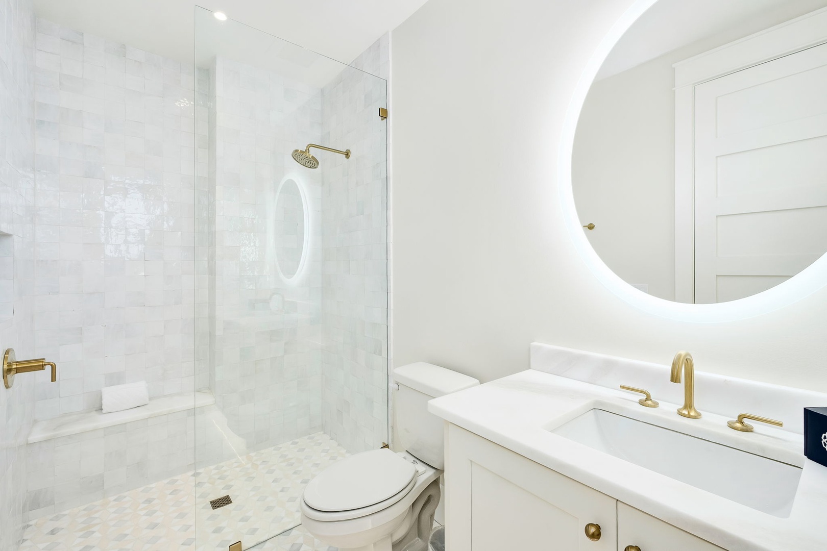 Refresh in your elegant bathroom with a spacious walk-in shower, gleaming brass fixtures, and a luminous mirror that makes morning routines feel like a retreat.