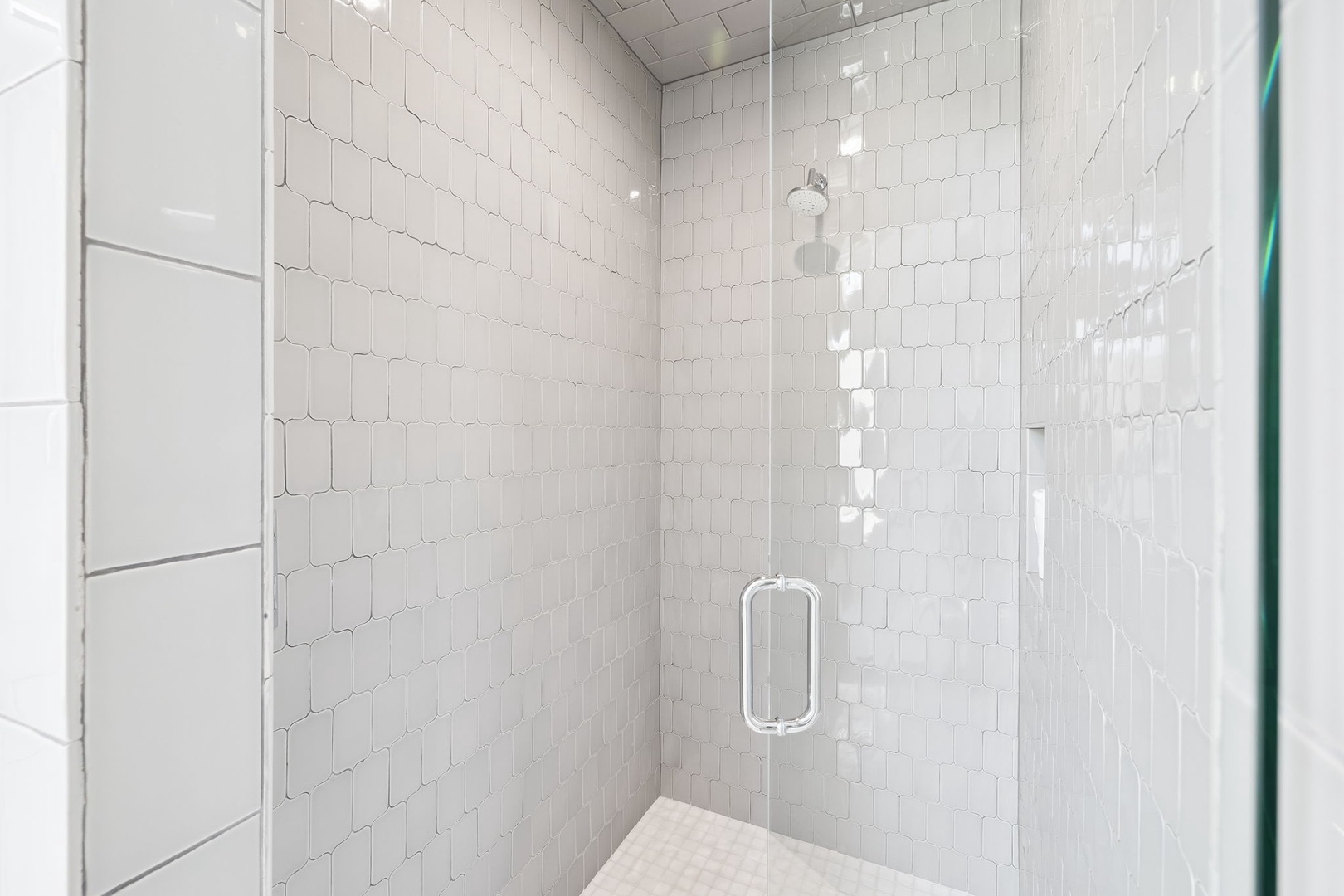 Step into your private glass-enclosed shower with elegant white hexagonal tiles and modern fixtures for a refreshing start to each day.
