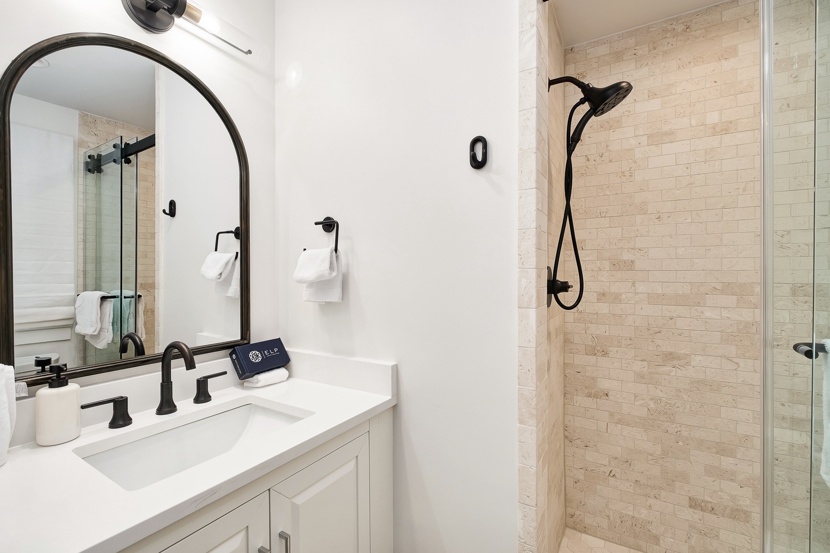 Step into your luxurious bathroom featuring elegant stone tile shower and sleek black fixtures for a spa-like retreat.
