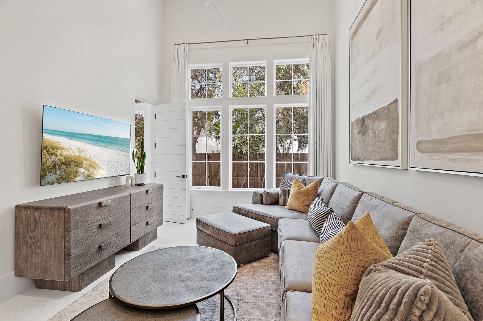 Sink into plush seating and unwind in your bright, coastal-inspired retreat with garden views and beach vibes on-screen.