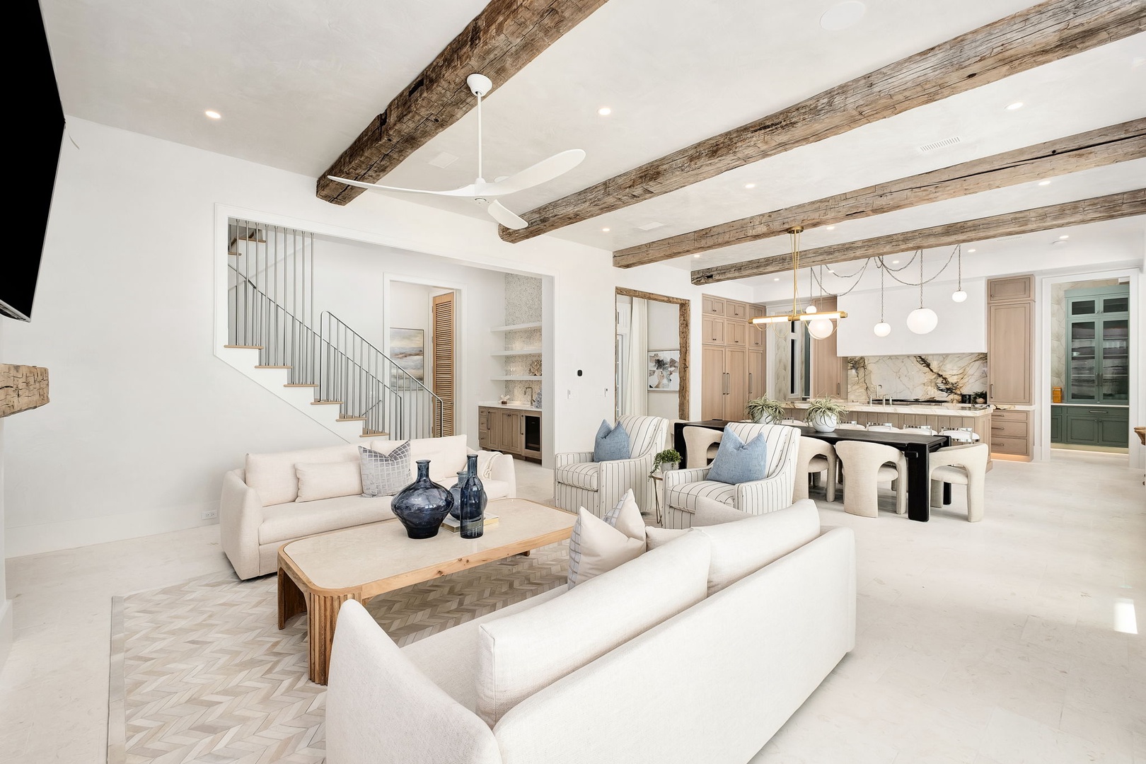 Unwind in your sophisticated open-plan living space, where rustic beams meet modern elegance and every detail invites relaxation.