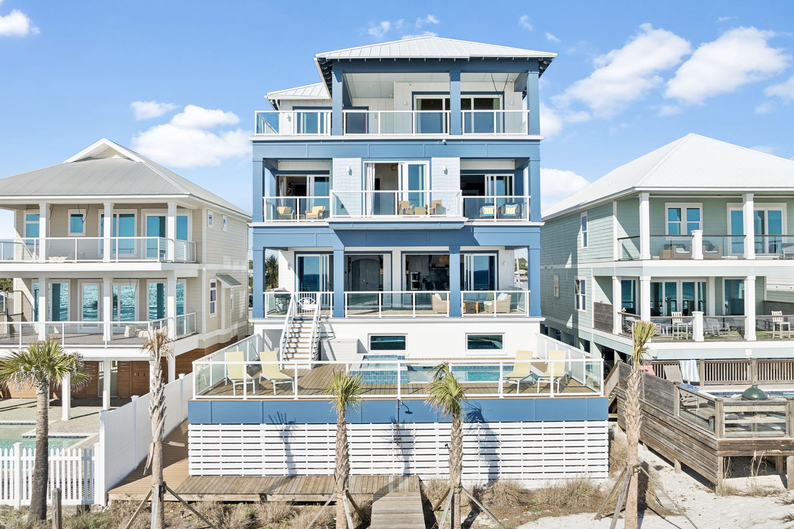 Stunning blue beach house featuring private pool and multiple decks overlooking pristine coastal surroundings.