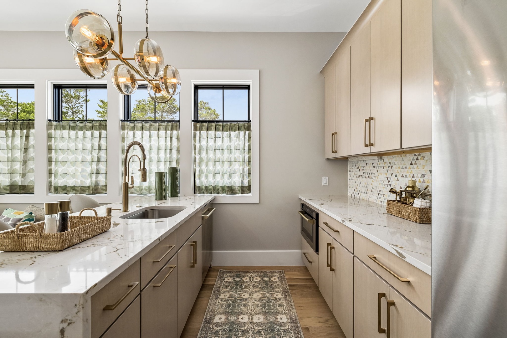Whip up your favorite meals in this modern kitchen with marble countertops, stylish cabinetry, and natural light streaming through large windows that brighten your cooking space beautifully.