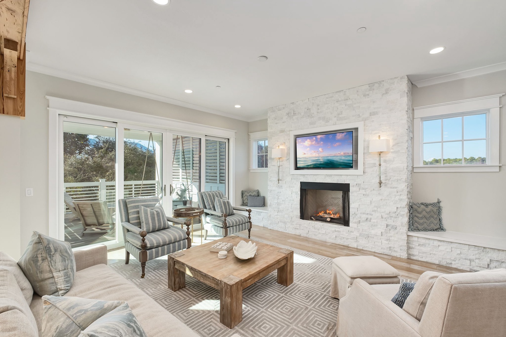 Sink into plush sofas by your crackling fireplace, where natural light streams through French doors opening to your private deck.
