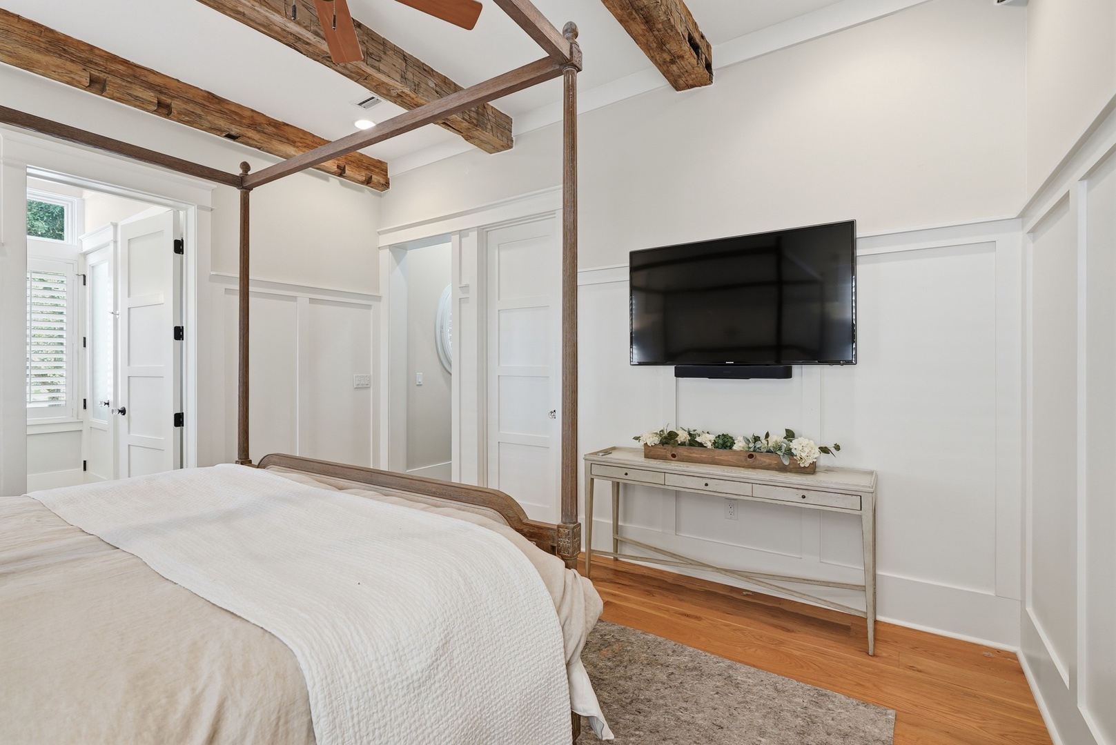 Unwind in your elegant bedroom featuring rustic exposed beams, a four-poster bed, and modern comforts—your perfect retreat after a day of adventure.