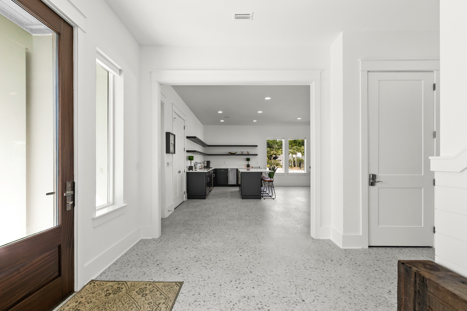 Step into your bright and welcoming home, where gleaming floors and soaring ceilings create an airy, spacious feel. The modern kitchen awaits just beyond, ready for your morning coffee and meal prep.