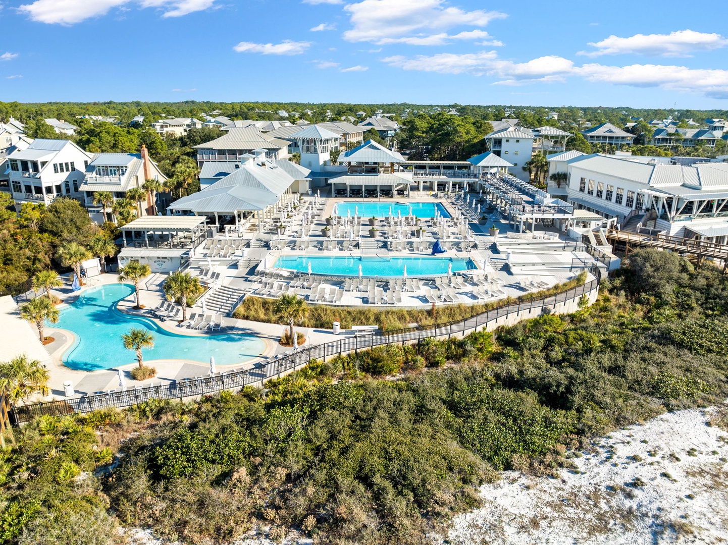 Aerial view showcasing the resort's expansive pool complex surrounded by coastal vegetation and vacation homes.