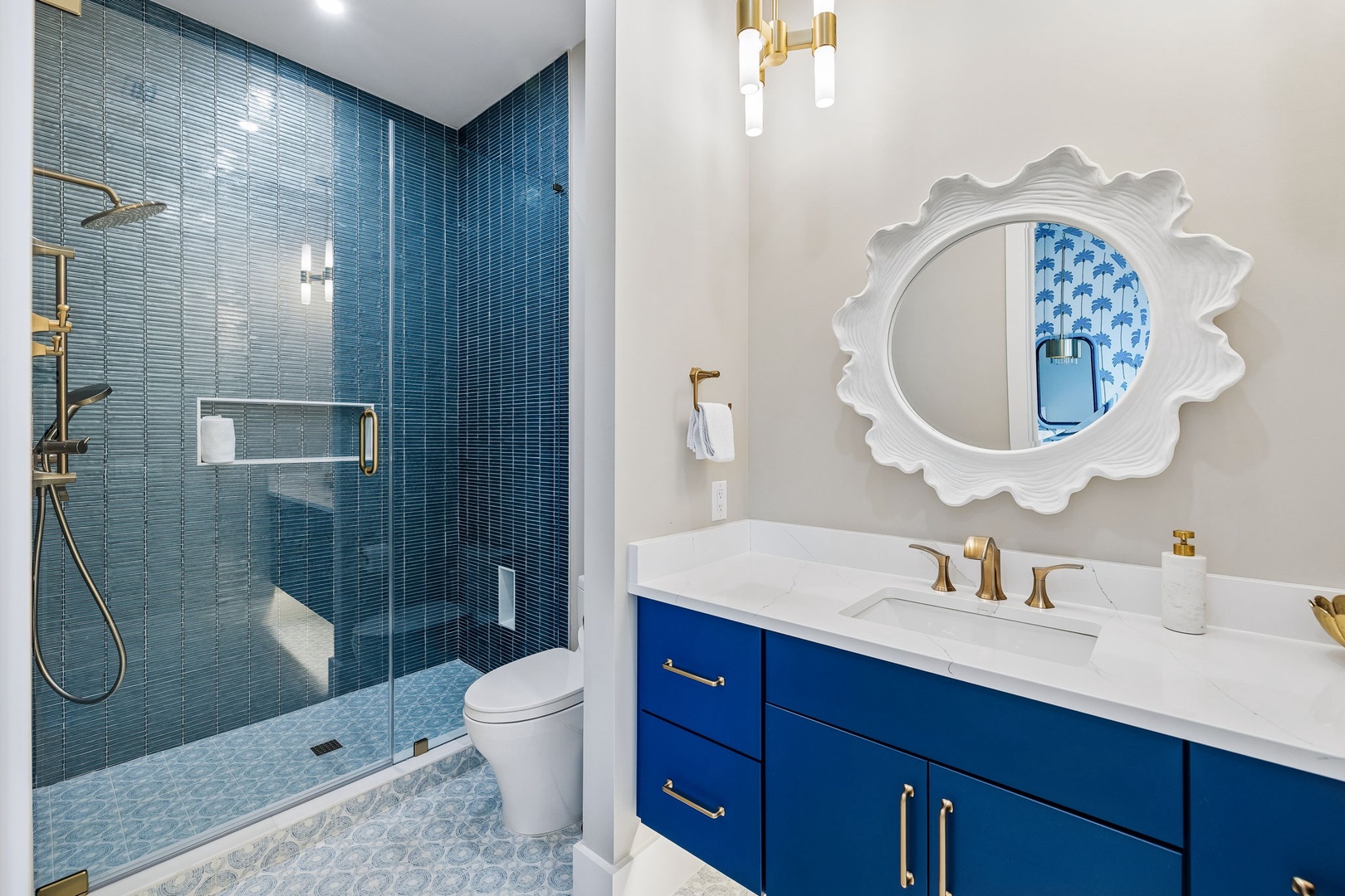 Step into your private spa retreat with stunning blue tile work and elegant gold fixtures. The spacious walk-in shower beckons you to unwind after a day of adventure.