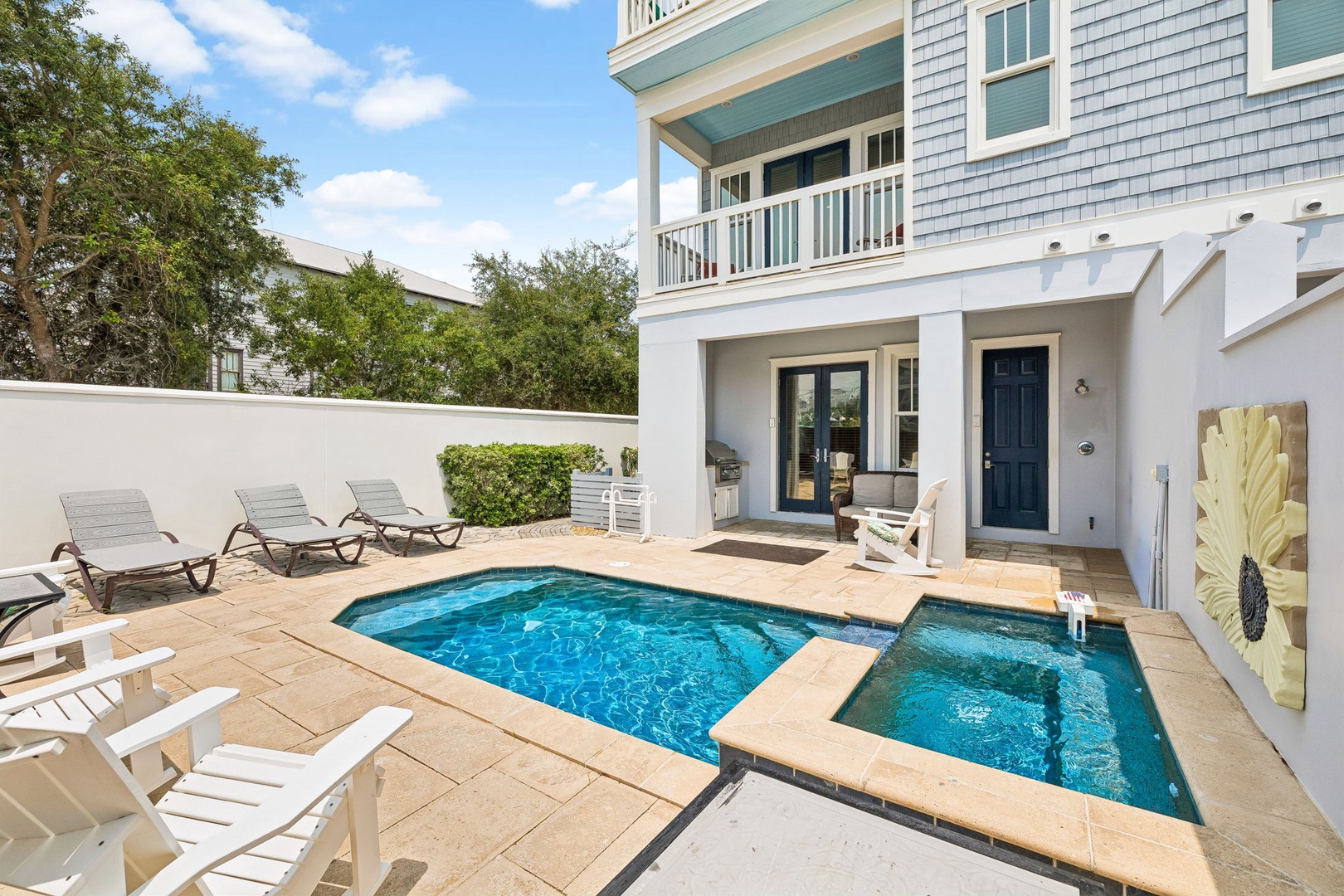 A beautiful coastal-style property featuring private pool and hot tub for your exclusive enjoyment. Relax on spacious loungers surrounded by lush greenery and easy balcony access.