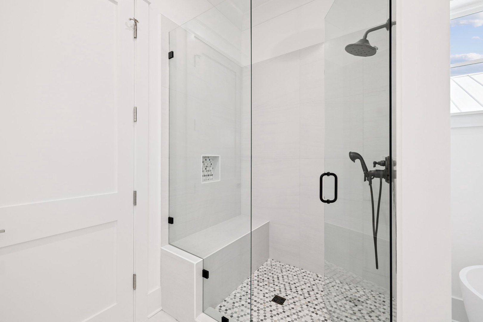 Step into your spa-like shower sanctuary with rainfall showerhead and elegant mosaic floors for the ultimate refreshing escape.