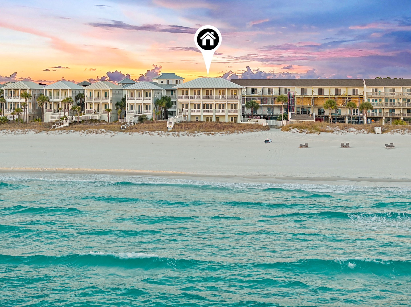Beachfront property nestled on pristine white sands, where turquoise waters meet colorful skies at sunrise—a stunning coastal retreat in a beautiful natural setting.