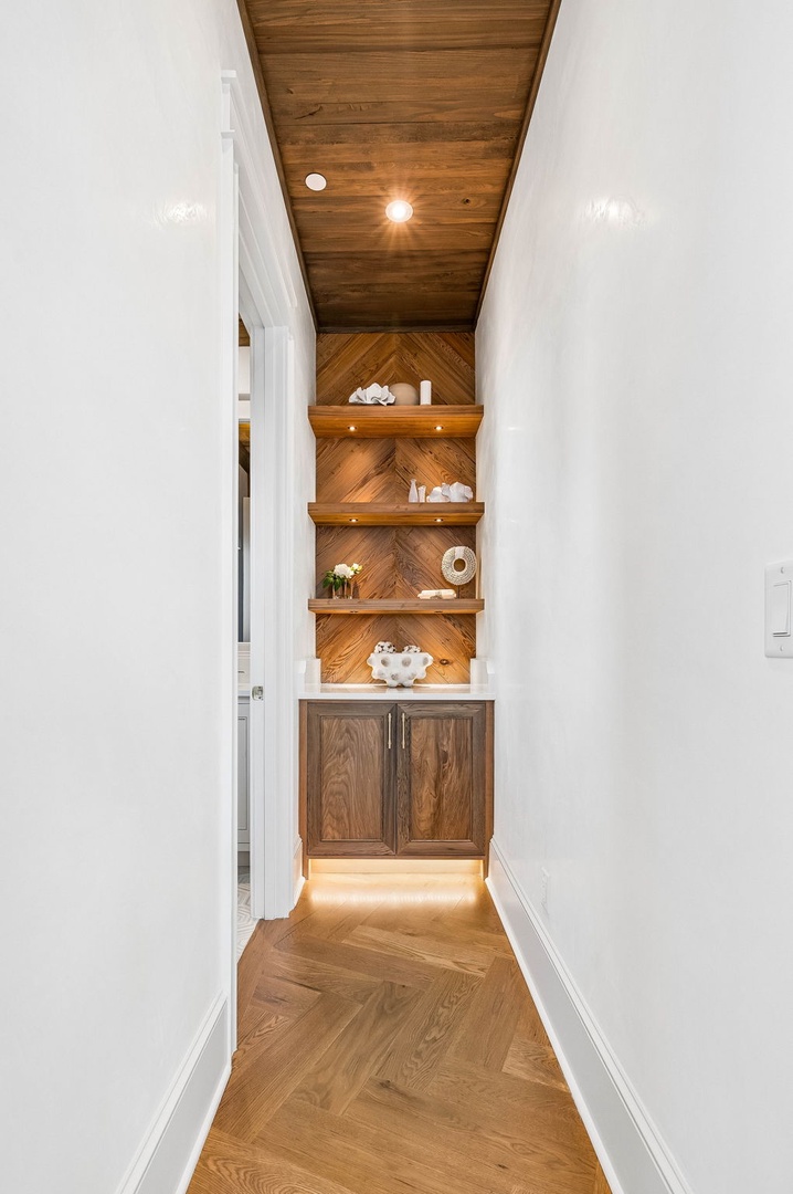 Step into your private hallway with herringbone wood details, custom shelving, and under-cabinet accent lighting that adds warmth and character to your personal space.
