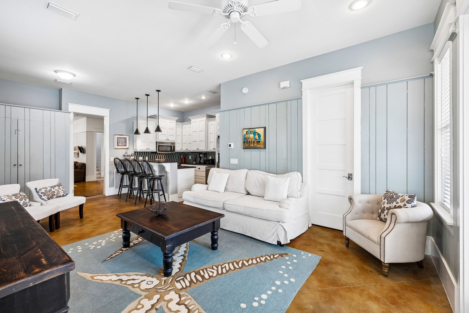 Relax in your spacious open living area with coastal-cottage charm, where soft seating invites you to unwind while the kitchen awaits your culinary adventures.