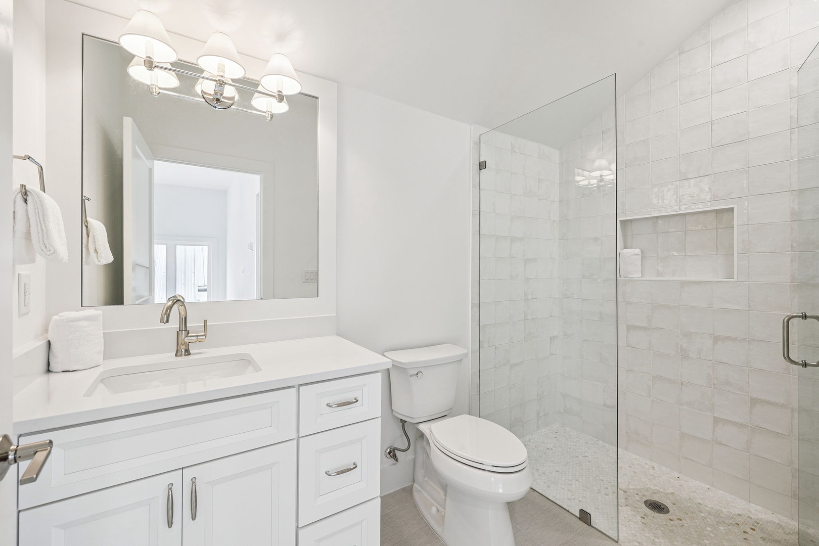 Refresh in your pristine bathroom featuring a spacious walk-in shower with modern fixtures and elegant marble-style finishes.