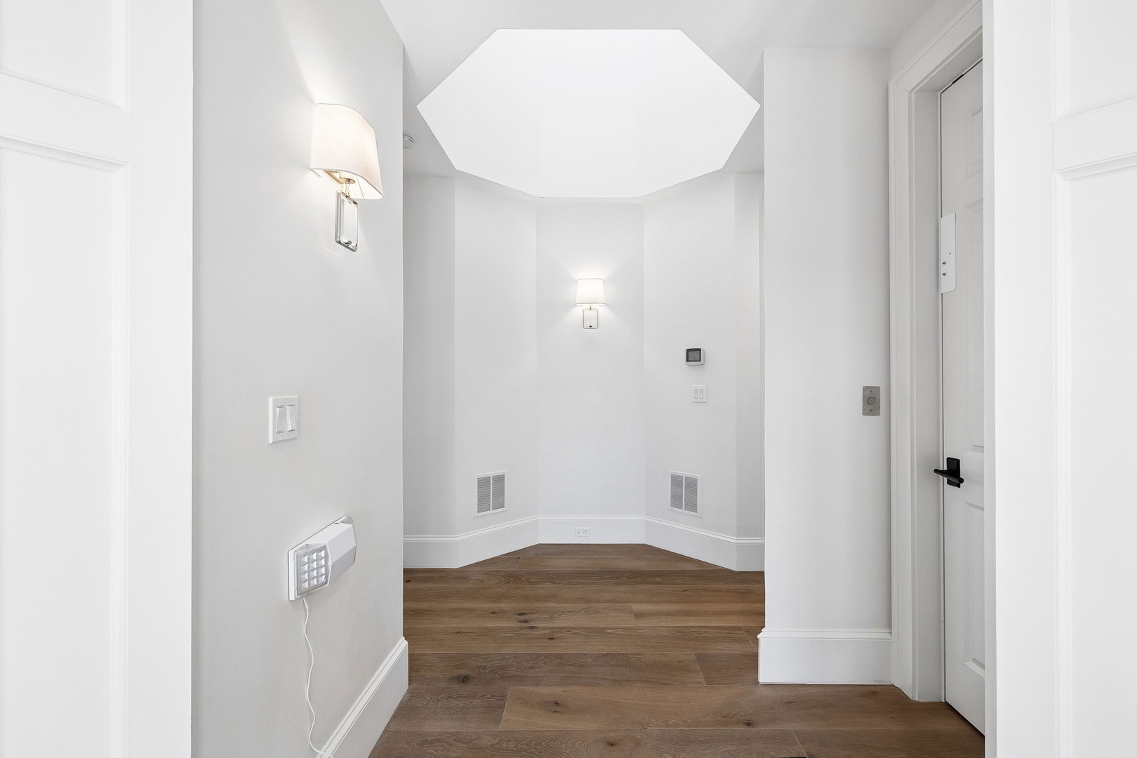 Step into this bright, modern space where warm wood floors meet crisp white walls, creating a welcoming retreat that feels both spacious and serene.
