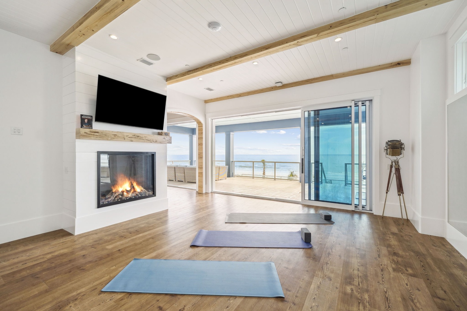 Your oceanfront sanctuary awaits with yoga mats ready, cozy fireplace crackling, and stunning sea views through floor-to-ceiling windows for ultimate relaxation.