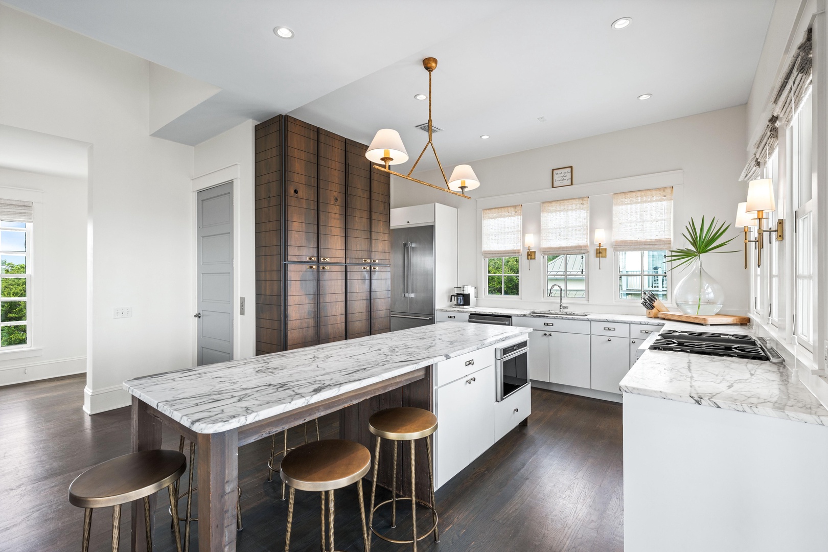 You'll love preparing meals in this stunning gourmet kitchen, featuring marble countertops, premium appliances, and elegant brass fixtures that create the perfect culinary sanctuary.
