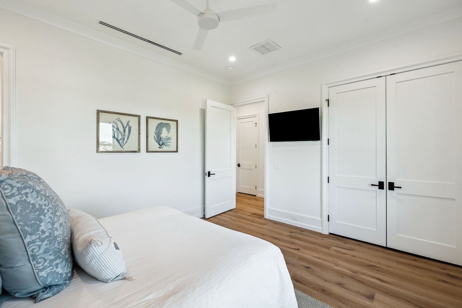 Drift into peaceful dreams in this crisp, elegant bedroom with modern comforts and coastal artwork creating your perfect retreat.