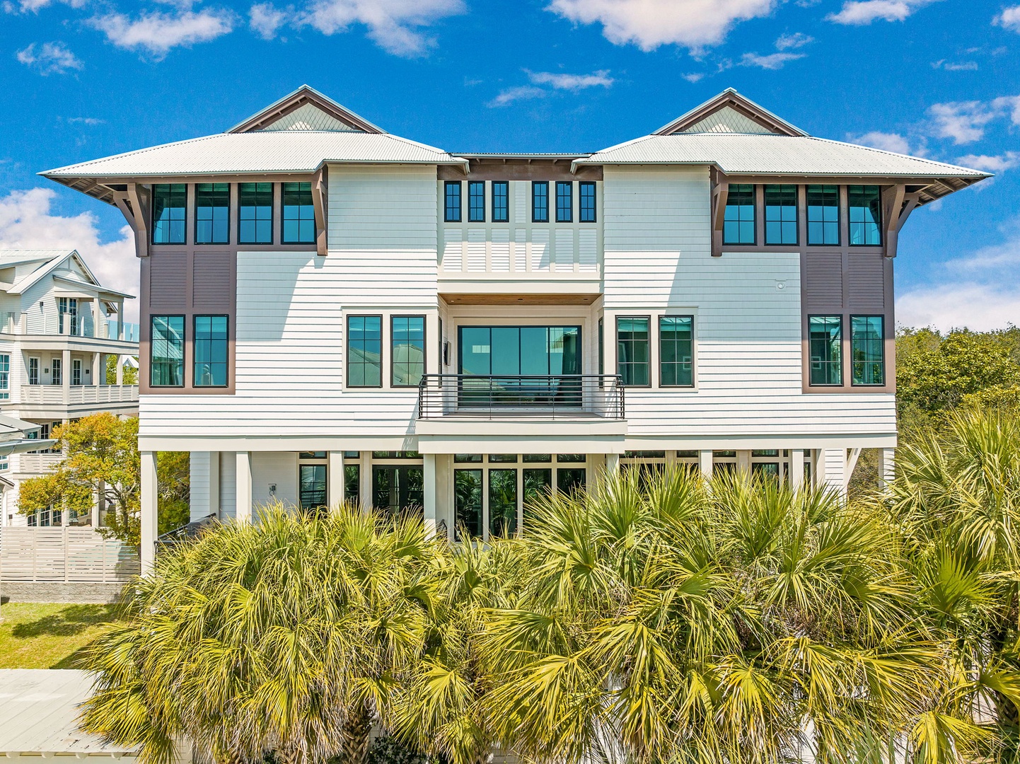 This elegant coastal home features sophisticated architecture with tropical landscaping in a peaceful residential setting.