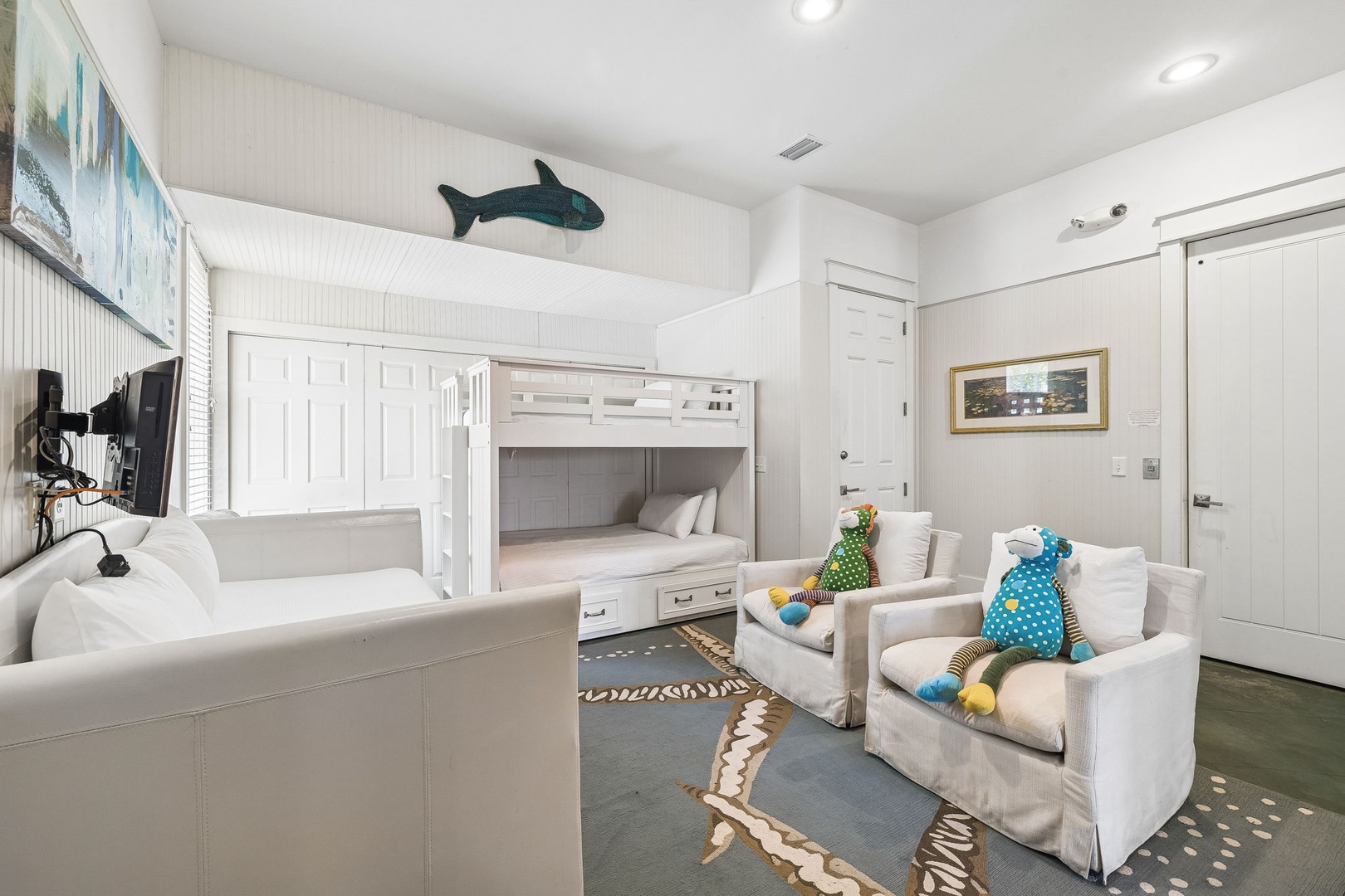 This cheerful coastal bedroom is perfect for kids, with cozy bunk beds, soft seating, and playful whale accents. Your family will love unwinding here after beach days.
