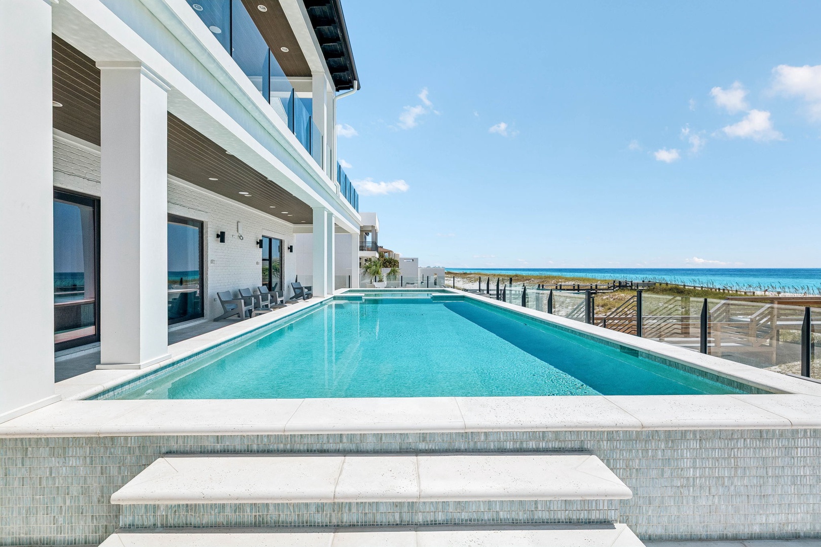 Modern beachfront property featuring pristine pool and direct beach access with stunning turquoise waters just steps away.