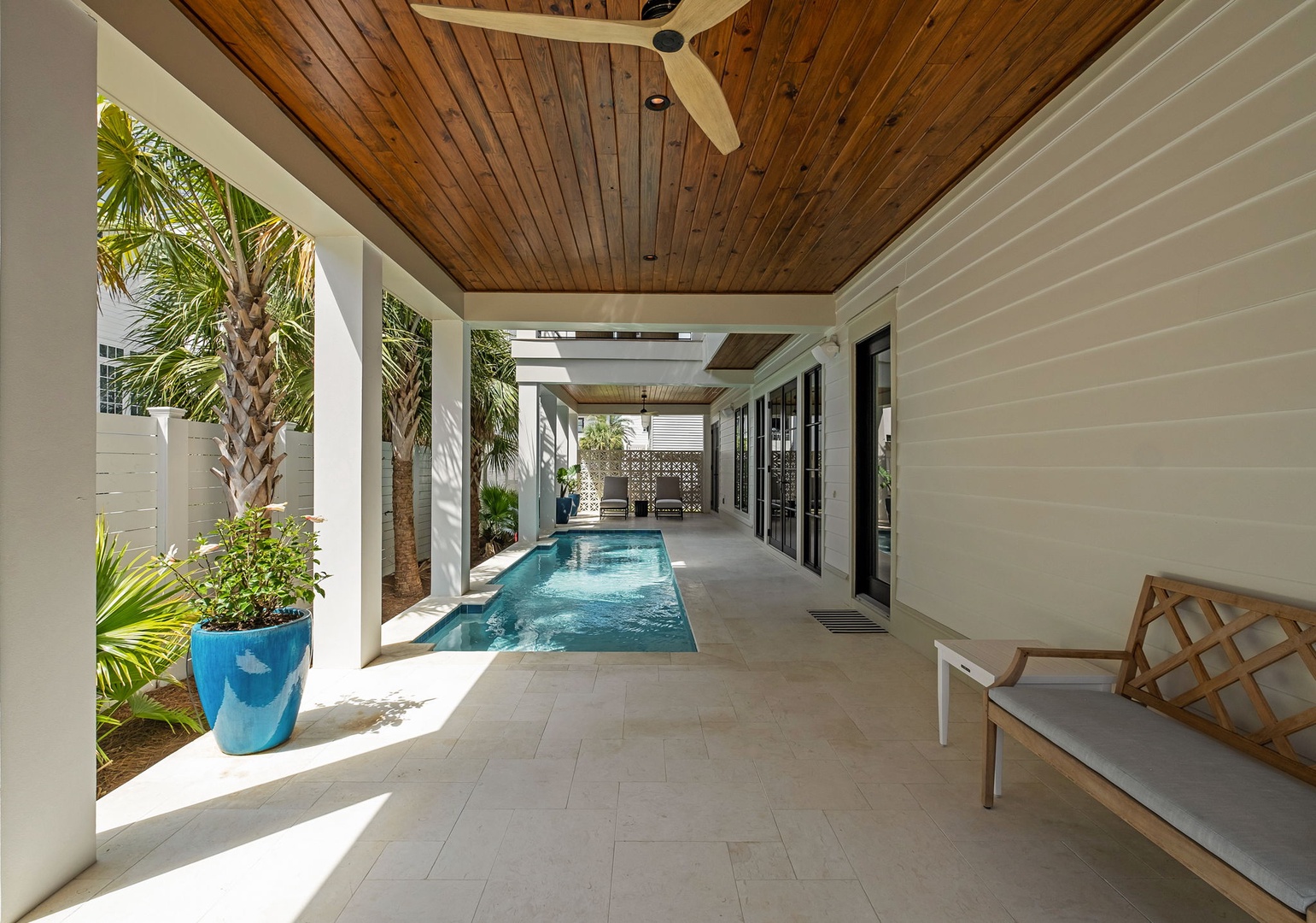 Step into your private tropical oasis where a stunning pool stretches beneath soaring wood-beamed ceilings and lush palms frame your serene escape.