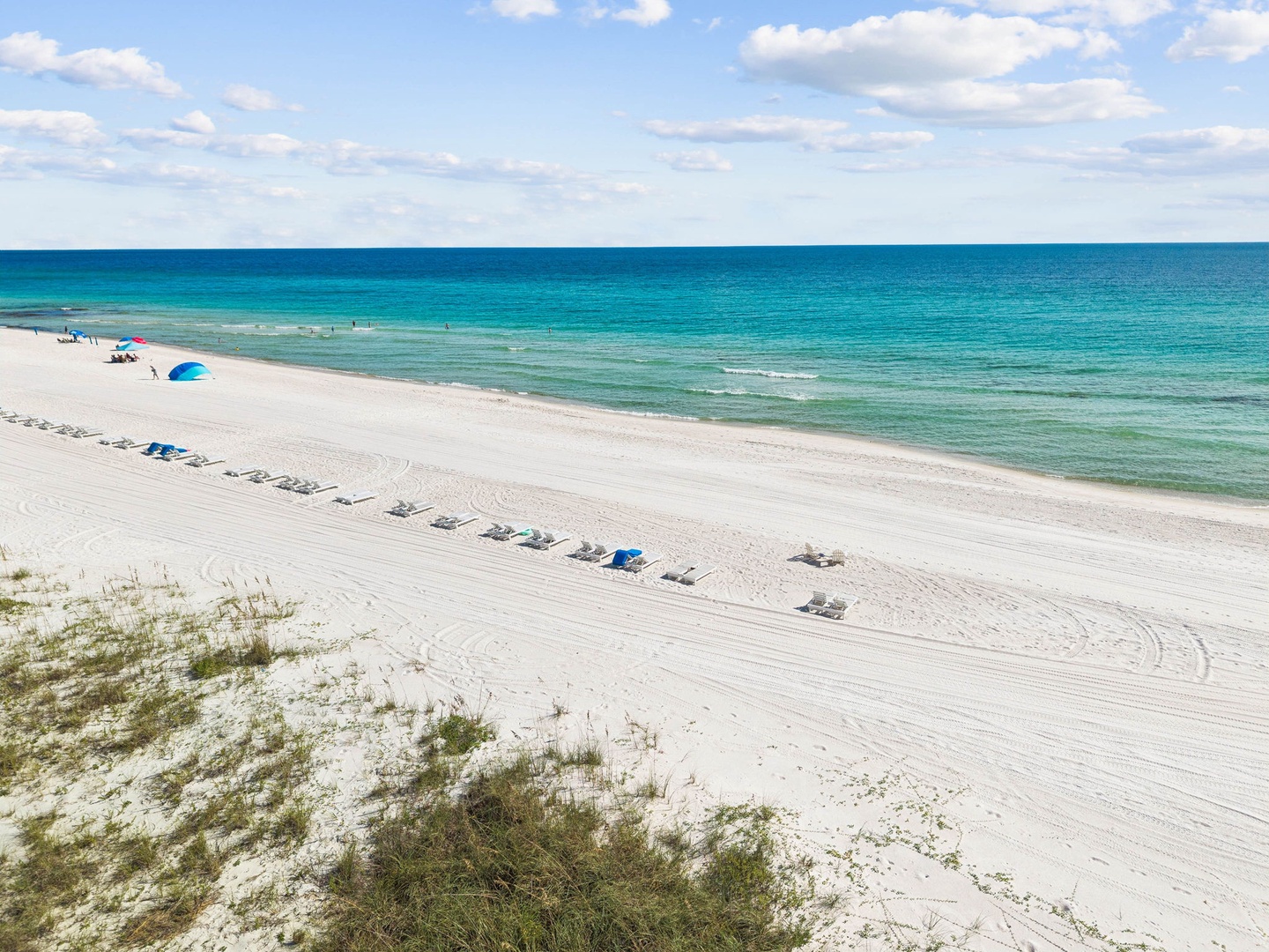 Pristine white sand beach with crystal-clear turquoise waters stretching to the horizon, located near the property and offering a serene coastal escape.